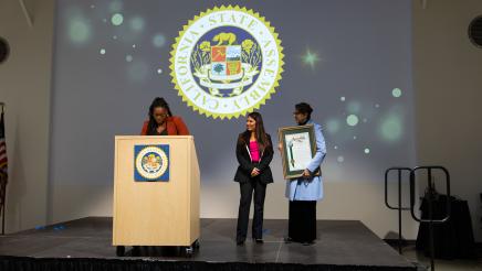 Asm. Ortega handing out Resolution plaque on stage