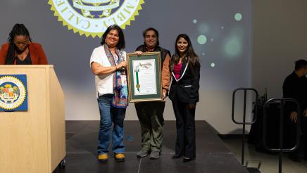 Asm. Ortega handing out Resolution plaque on stage