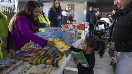 Asm. Ortega handing books to kids at Diaper Drive